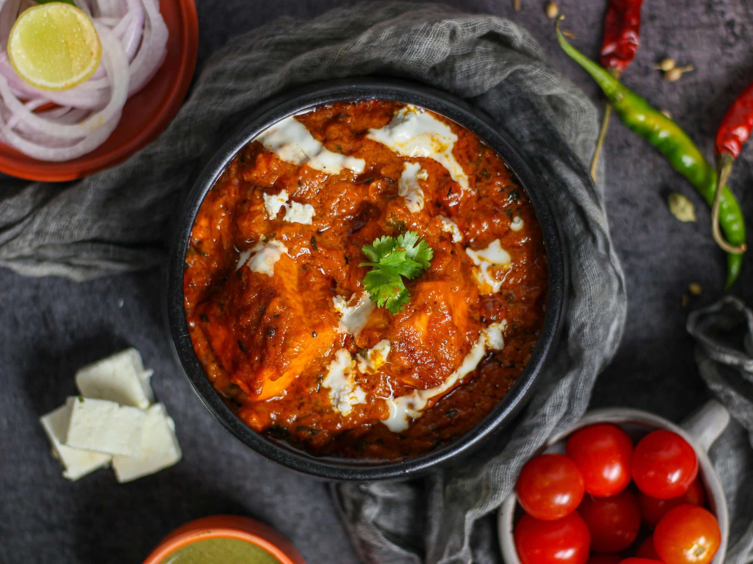 Indisk butter chicken med kremet tomatsaus og koriander – krydret gryterett servert i bolle